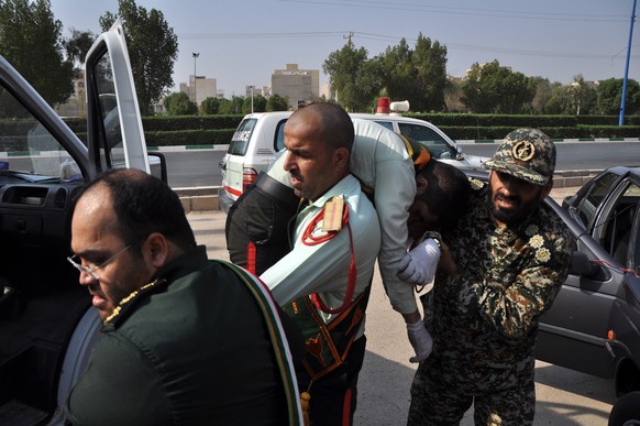 epa07038535 An Iranian soldier carries his friend who was injured in a terror attack during a military parade in the city of Ahvaz, southern, Iran, 22 September 2018. Media reported that Gunmen have o ...
