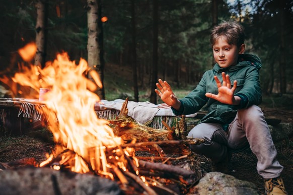 Junge vor dem Lagerfeuer