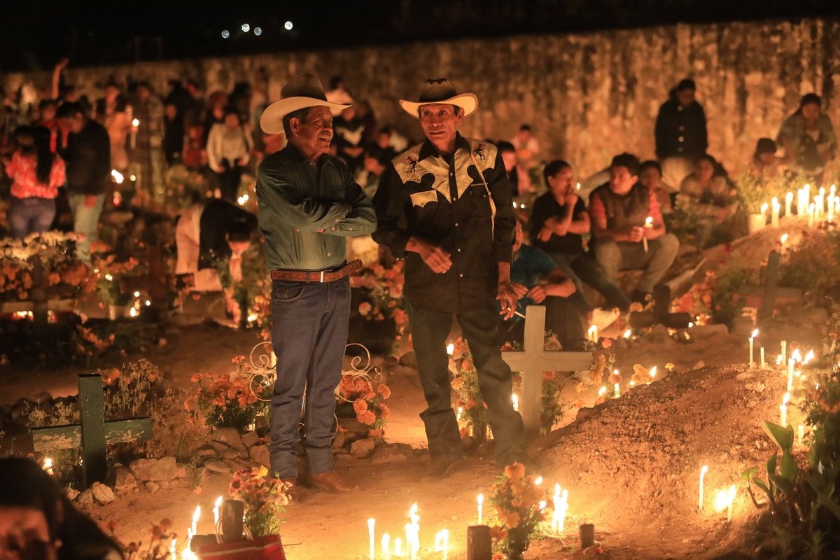 epa10280801 Families illuminate the graves of their loved ones, in the municipal pantheon of the municipality of Huitziltepec, Guerrero state, Mexico, 01 November 2022. Mexican families once again fil ...