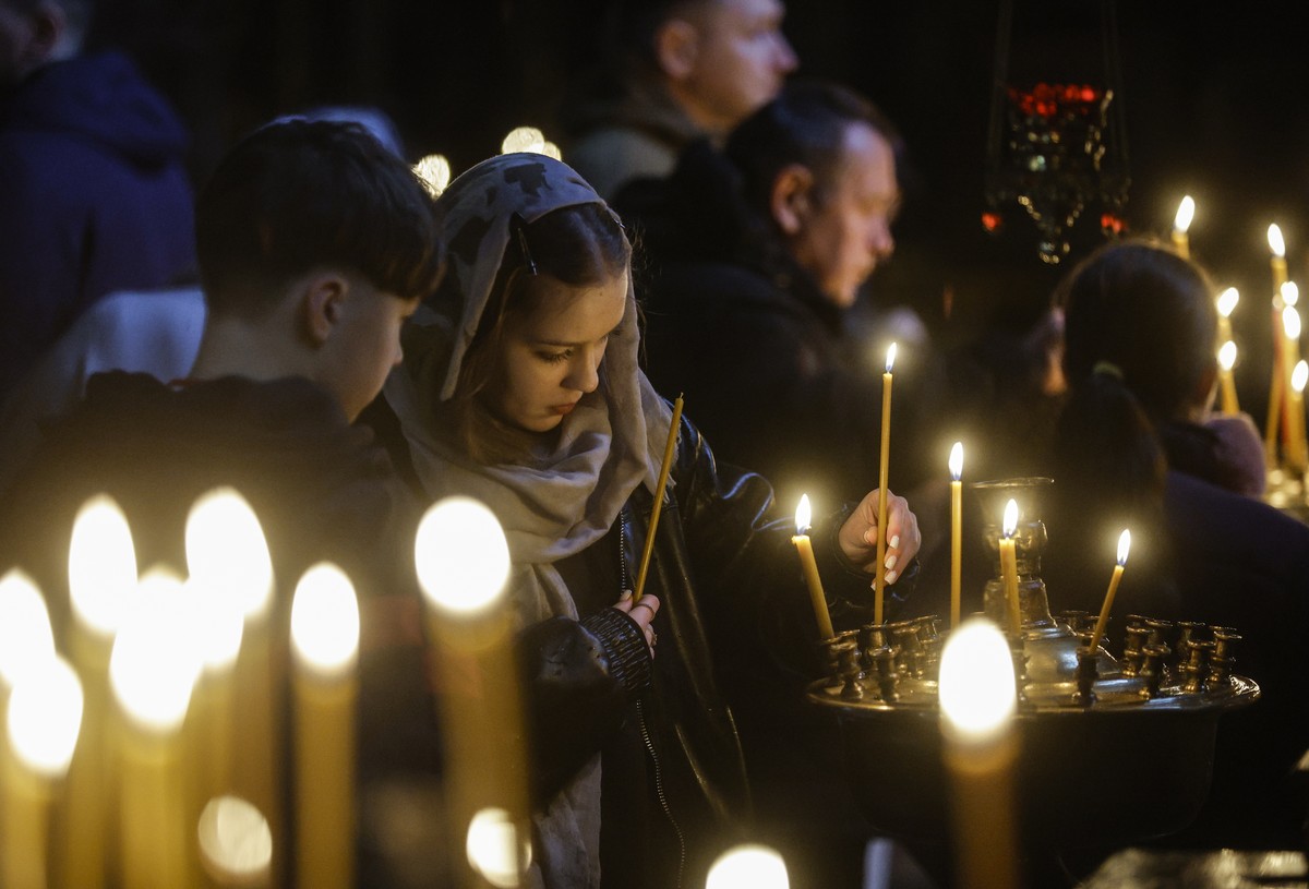 epa12883703 Ukrainian believers light candles at St. Volodymyr's Cathedral in Kyiv, Ukraine, 11 April 2026, one day before the Orthodox Easter celebration. Ukrainian faithful celebrate Easter on  ...