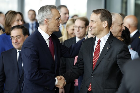 NATO Secretary General Jens Stoltenberg, left, shakes hands with Poland&#039;s Foreign Minister Radoslaw Sikorski a ceremony to mark the 75th anniversary of NATO at NATO headquarters in Brussels, Thur ...