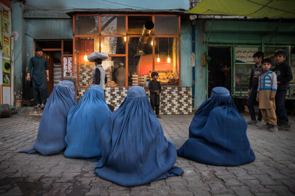 Food Crisis - Afghanistan EDITORIAL USE ONLY - Burqa-clad Afghan women wait for donations of bread outside a Kabul bakery. The majority of them come here every day and wait three hours for a piece of  ...