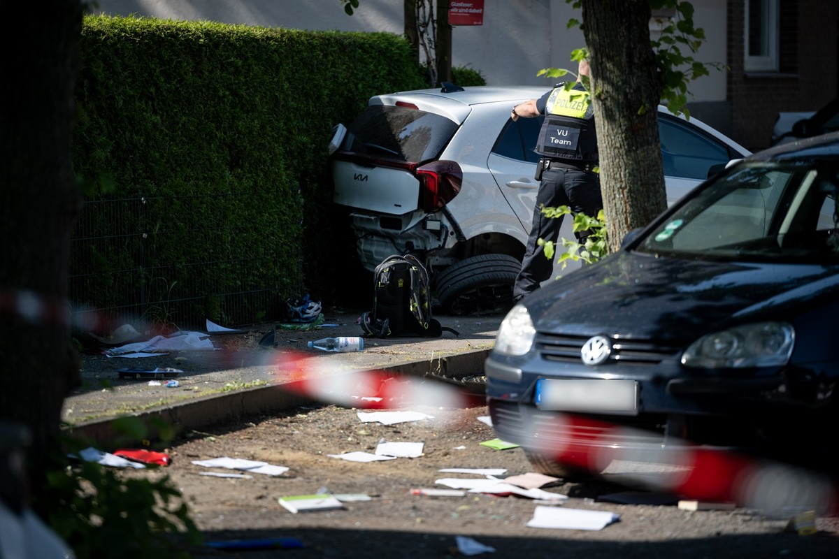27.05.2026, Nordrhein-Westfalen, Dinslaken: Ein Schulrucksack liegt auf dem Boden vor besch�digten Autos. Die Polizei sichert eine Unfallstelle, nachdem eine Autofahrerin drei Kinder vor einer Schule  ...