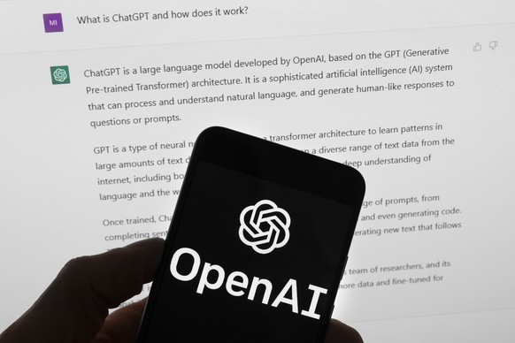 FILE - The OpenAI logo is seen on a mobile phone in front of a computer screen which displays output from ChatGPT, Tuesday, March 21, 2023, in Boston. White House officials concerned about AI chatbots ...