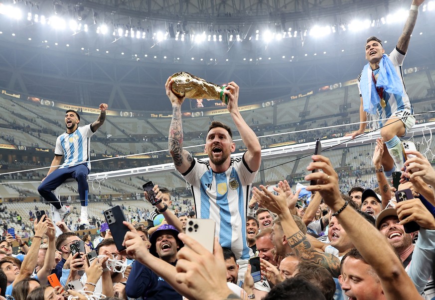 epa13202784 (FILE) - Lionel Messi of Argentina (C) lifts the trophy as he celebrates with teammates and fans winning the FIFA World Cup 2022 Final between Argentina and France at Lusail stadium, Lusai ...