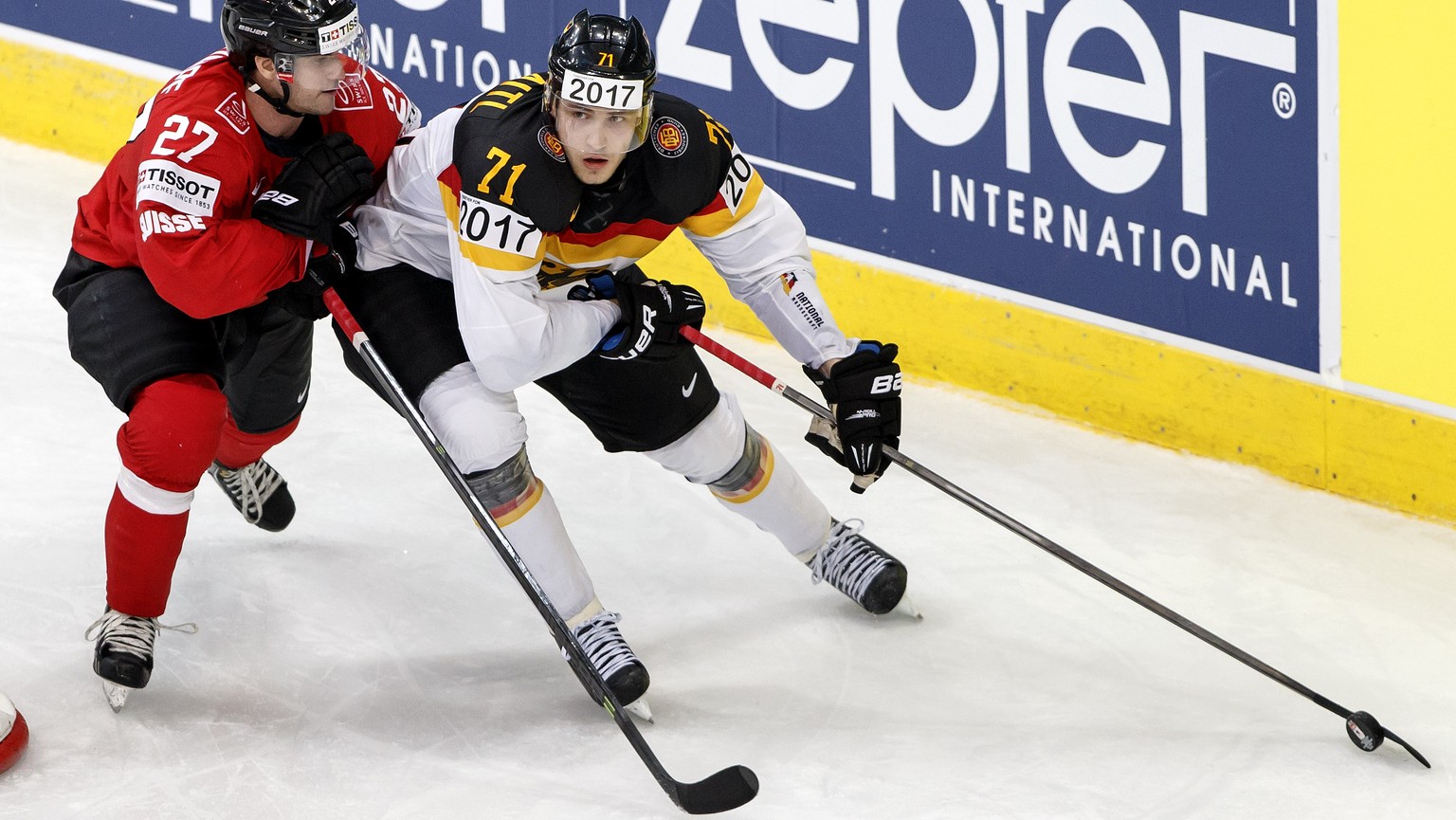 Switzerland&#039;s Dominik Schlumpf, 2nd left, vies for the puck with Germany&#039;s Leon Draisaitl, right, next to Switzerland&#039;s goaltender Reto Berra, left, during the 2014 IIHF Ice Hockey Worl ...