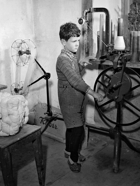 Bub bei der Heimarbeit am Spinnrad, um 1940.