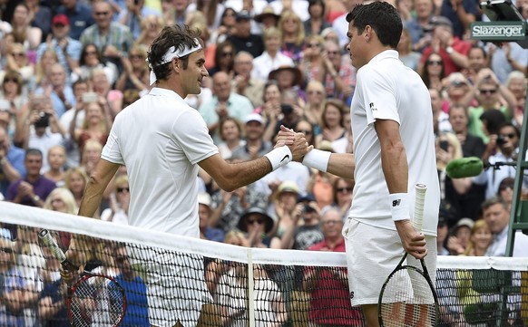 epa05415558 Milos Raonic of Canada (R) at the net with Roger Federer of Switzerland whom he defeated in their semi final match during the Wimbledon Championships at the All England Lawn Tennis Club, i ...