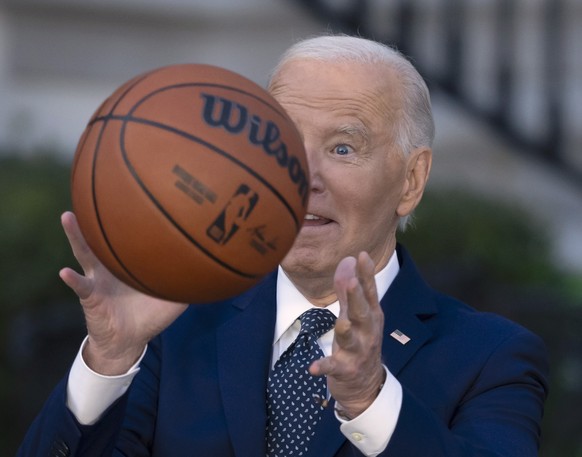 President Joe Biden throws a basketball he received from the Boston Celtics at an event to celebrate the team&#039;s victory in the 2024 National Basketball Association Championship, on the South Lawn ...