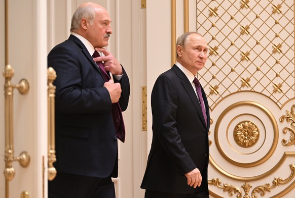 epa10374244 Russian President Vladimir Putin (R) and Belarusian President Alexander Lukashenko enter a hall for joint news conference following their talks at the Palace of Independence in Minsk, Bela ...