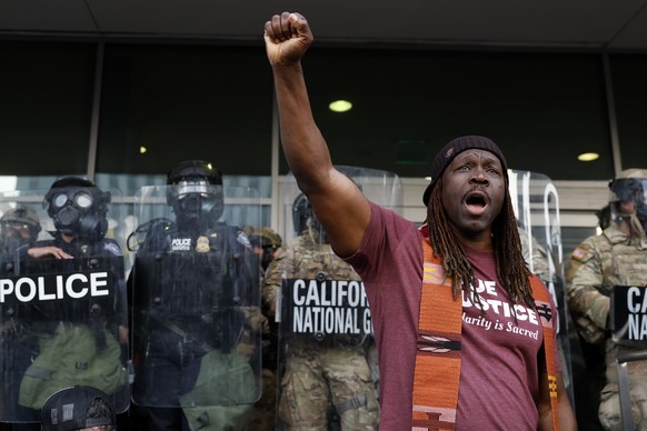 epa12169451 A protester stands outside the Edward R. Roybal Federal Building in Los Angeles, California, USA, 10 June 2025. US President Donald Trump has deployed 2,000 National Guard troops, despite  ...