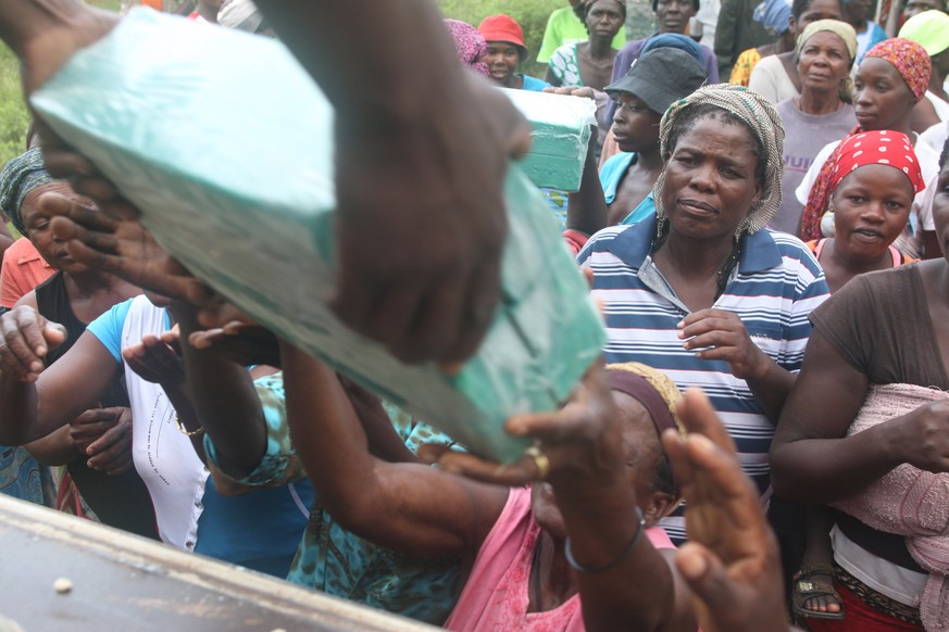 epa05826485 A handout photo made available by Unicef Zimbabwe shows families displaced by flooding receiving supplies after they were rescued following heavy rains, at a school in Tsholotsho, Zimbabwe ...