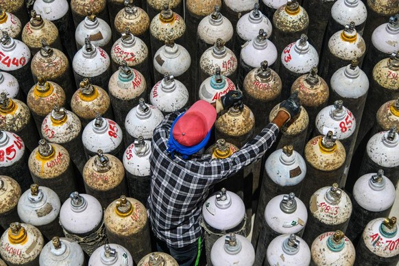 AJMER, RAJASTHAN, INDIA - 2021/04/23: Indian worker sort oxygen cylinders being used for Covid-19 patients at a facility in Jawaharlal Nehru Hospital in Ajmer. Major hospitals in New Delhi on Friday b ...