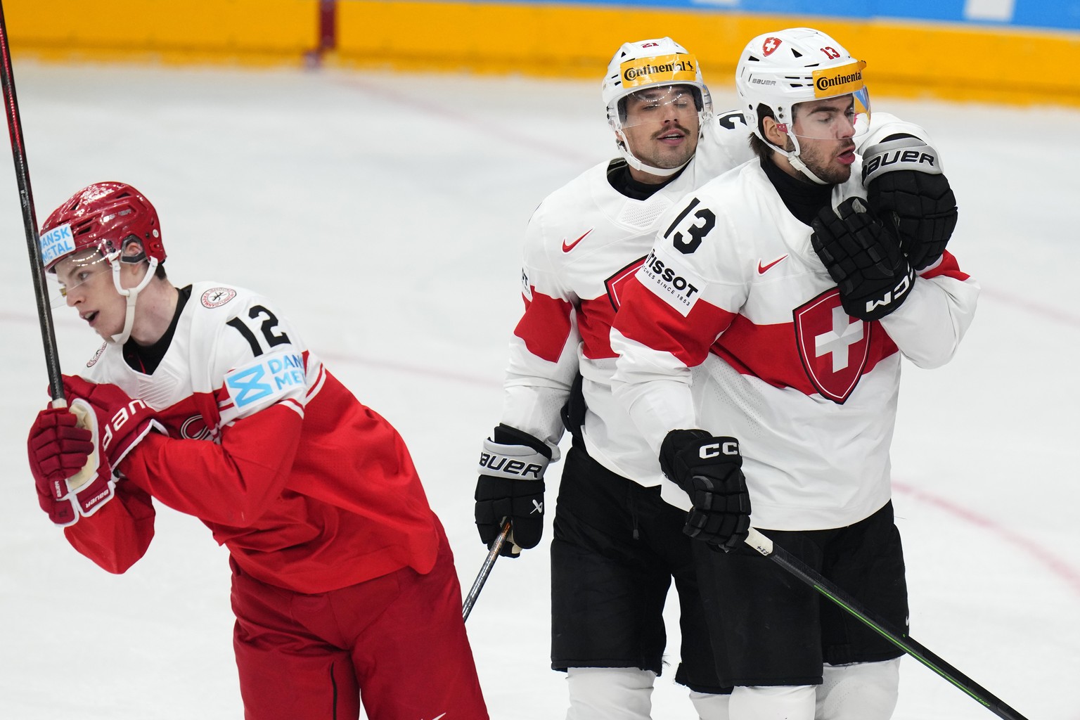 Denmark&#039;s Oscar Molgaard, left, skates past as Switzerland&#039;s Nico Hischier, right, celebrates with Switzerland&#039;s Kevin Fiala after scoring his sides first goal during the preliminary ro ...