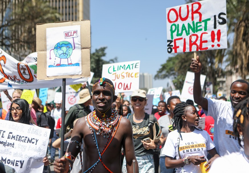 epa07855730 A Kenyan Massai man (C), joins hundreds of youths and students during a protest against climate change in the streets of Nairobi, Kenya, 20 September 2019. Millions of people around the wo ...
