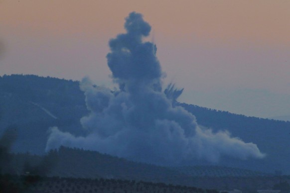 Plumes of smoke and dirt rise on the air from inside Syria, as seen from the outskirts of the border town of Kilis, Turkey, Saturday, Jan. 20, 2018. Turkish jets have begun an aerial offensive, codena ...