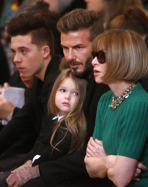 FILE - This is a Sunday, Feb. 15, 2015 file photo of David Beckham, center, as he sits in the front row next to Anna Wintour, right, along with his son, Brooklyn, left, daughter, Harper, before the Vi ...