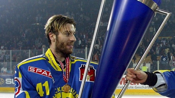 HC Davos-Goalie Lars Weibel, links, und Lonny Bohonos, rechts, tragen den Meisterpokal nach dem NLA Eishockey Playoff Finalspiel zwischen den ZSC Lions und dem HC Davos am Samstag, 6. April 2002, in Z ...
