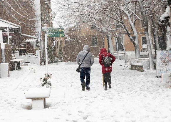 Untypisches Bild: Zwei Leute gehen in Mallorca durch dichten Schneefall.