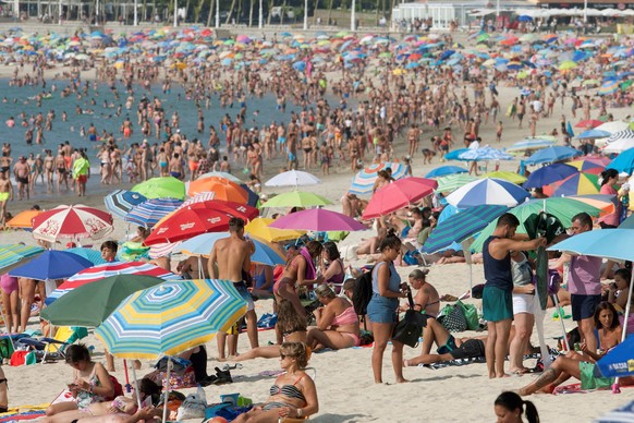 epa06962882 People crowd the Samil beach to enjoy at hot and sunny day in Vigo, northern Spain, 21 August 2018. Temperatures of more than 30 degrees Celsius were reached in the region these days and m ...