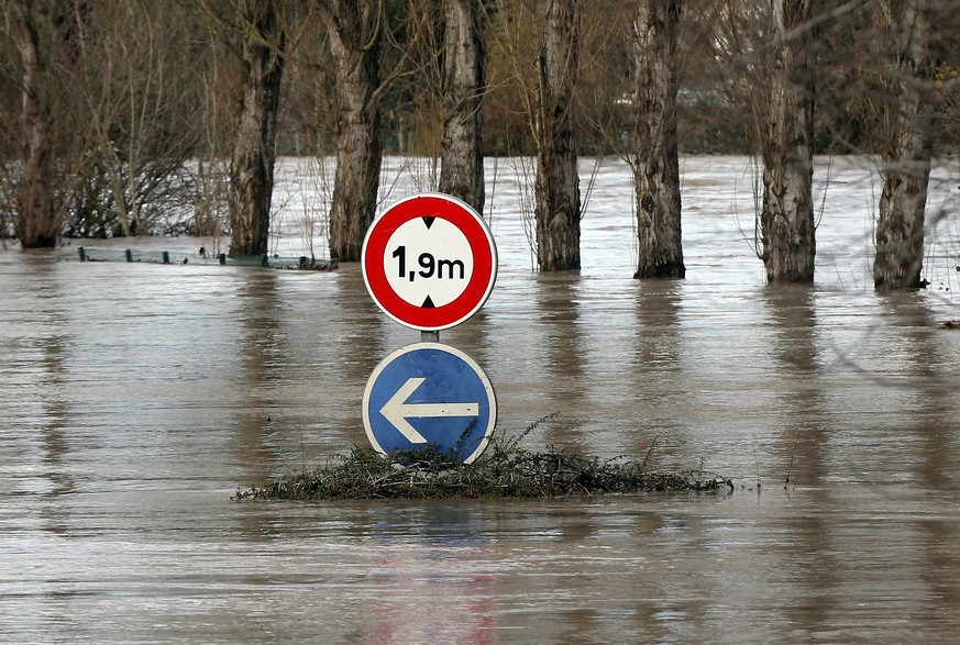 A road sign visible on a flooded road in Peyrorade, southwestern France, caused by heavy rains, Saturday, Dec. 14, 2019. Southwestern France is on alert for violent storms, high winds and floods. (AP  ...