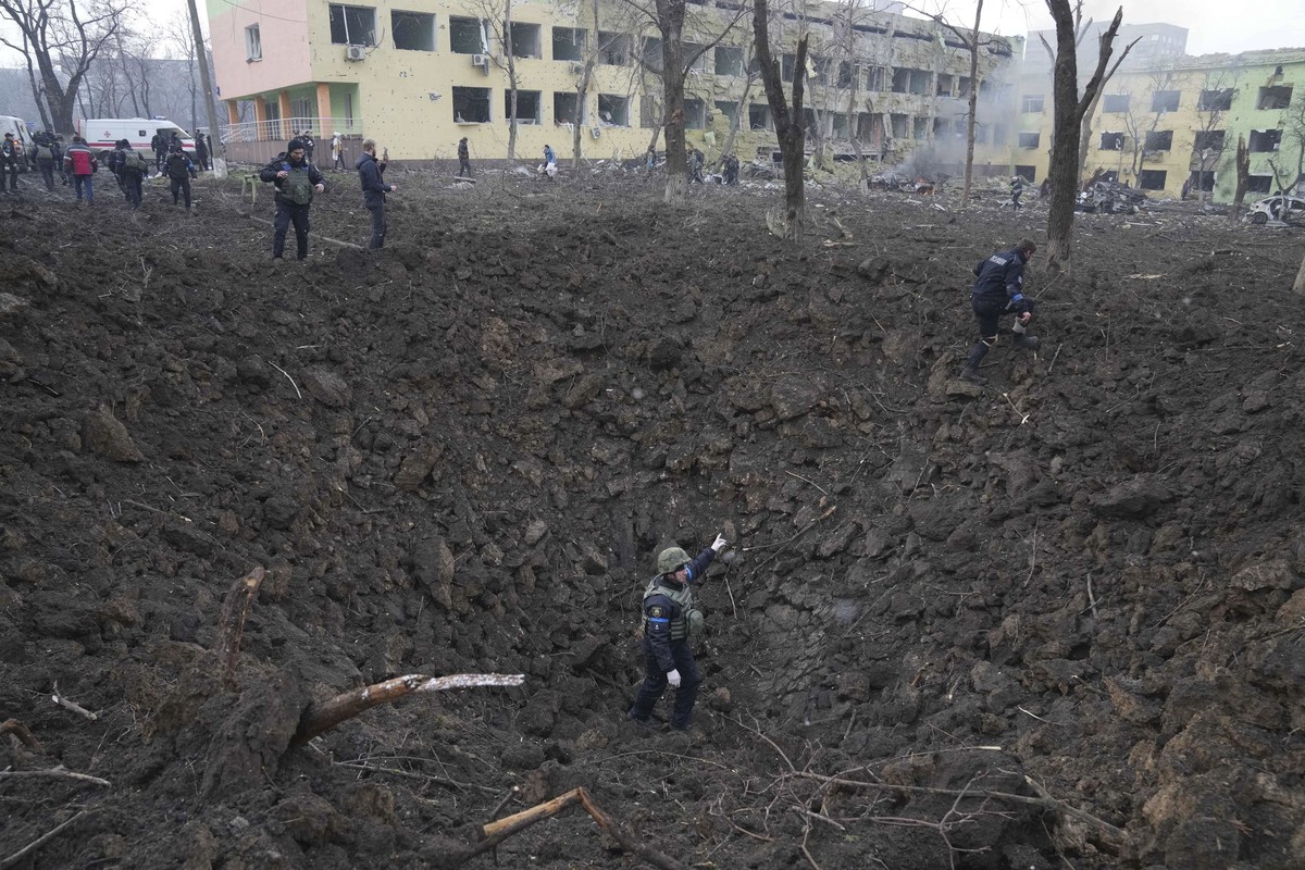 Ukrainian soldiers and emergency employees work at the side of the damaged by shelling maternity hospital in Mariupol, Ukraine, Wednesday, March 9, 2022. A Russian attack has severely damaged a matern ...