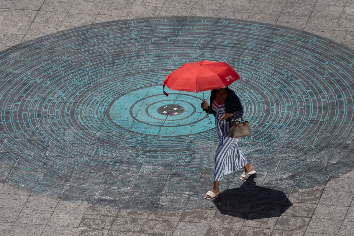 KEYPIX - epa13103319 A woman uses an umbrella to shield herself from the sun on a hot day in Frankfurt am Main, Germany, 10 July 2026. EPA/MATIAS BASUALDO