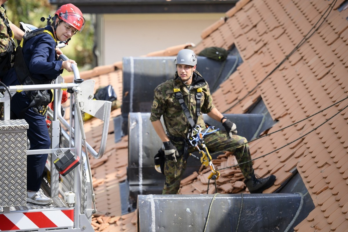 La conseillere federale Viola Amherd, gauche, discute avec un militaire qui travail sur un toit endommage lors de la visite des troupes de l'Armee Suisse engagees apres la tempete qui a frappe le ...