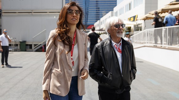 epa07531557 Former Formula One chairman Bernie Ecclestone (R) with his wife Fabiana Flosi (L) walk through the paddock at the Baku City Circuit in Baku, Azerbaijan, 27 April 2019. The 2019 Formula One ...