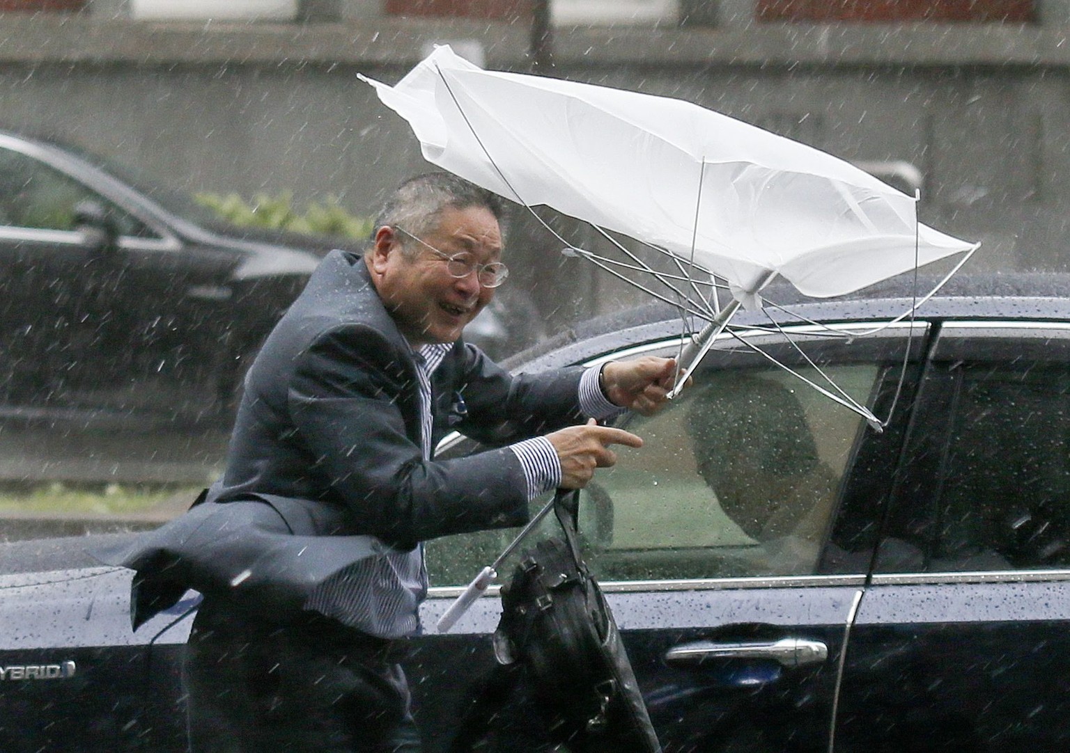 Ein Geschäftsmann kämpft in Tokyo gegen den Wind.