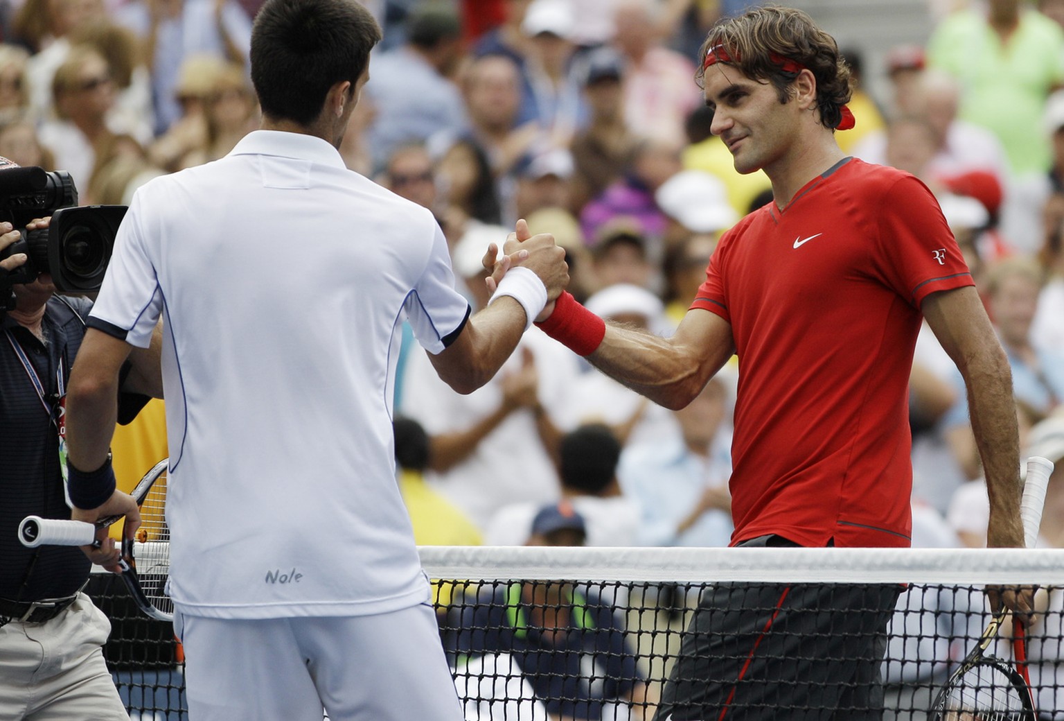 Roger Federer of Switzerland, right, shakes hands with Novak Djokovic of Serbia after losing a semifinal match at the U.S. Open tennis tournament in New York, Saturday, Sept. 10, 2011. (AP Photo/Matt ...