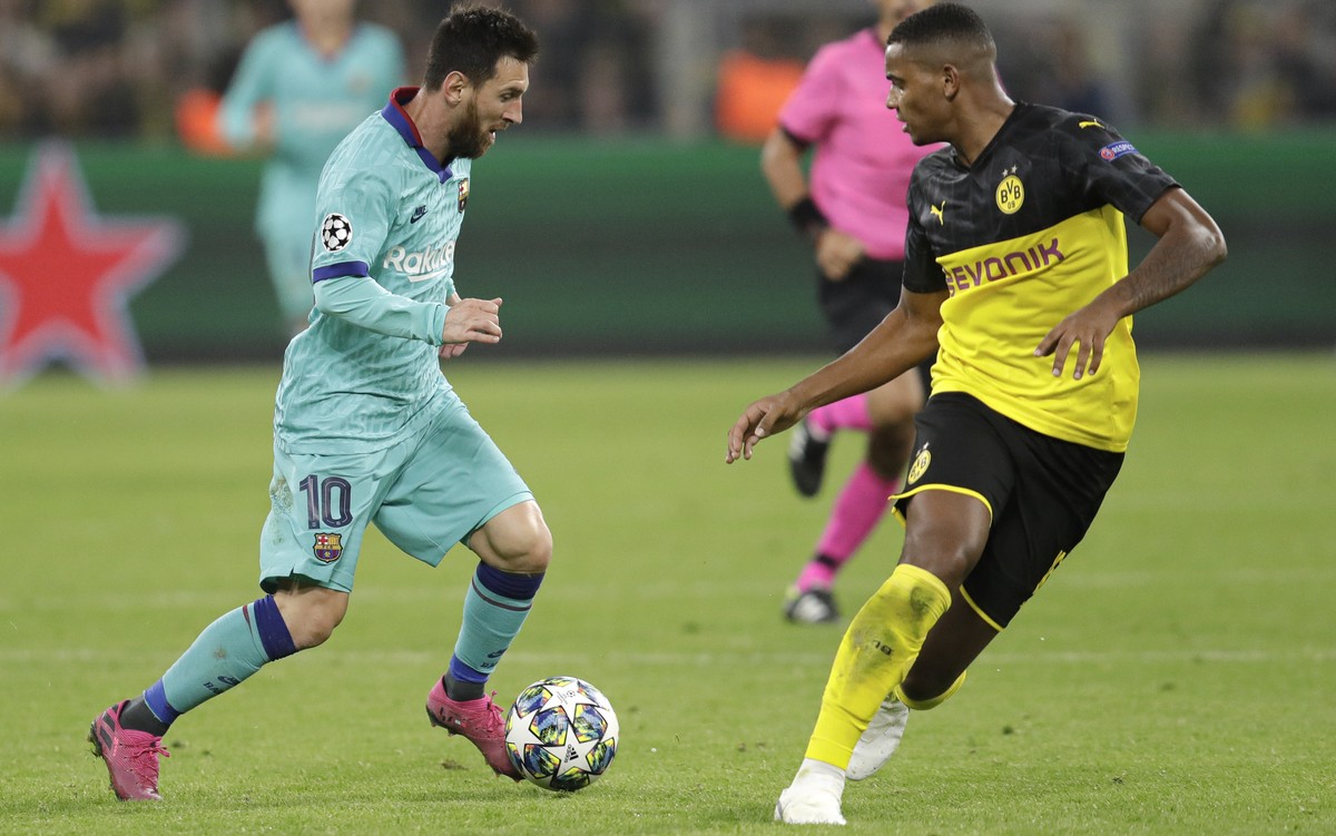 Barcelona's Lionel Messi challenges for the ball with Dortmund's Manuel Akanji during the Champions League Group F soccer match between Borussia Dortmund and FC Barcelona in Dortmund, German ...
