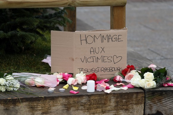 epa07225743 Flowers, candles and a sign reading &#039;Tribute to the victims - Je Suis Strasbourg&#039; are left where a person was killed during the Christmas Market shooting in Strasbourg, France, 1 ...