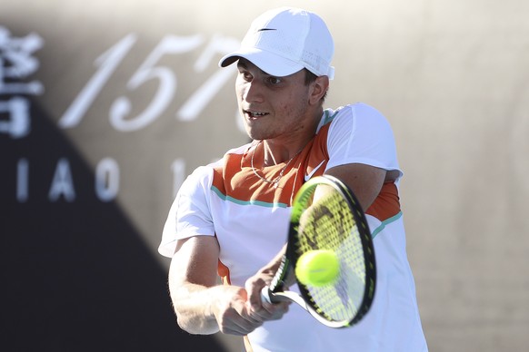 Miomir Kecmanovic of Serbia plays a backhand return to Salvatore Caruso of Italy during their first round match at the Australian Open tennis championships in Melbourne, Australia, Monday, Jan. 17, 20 ...