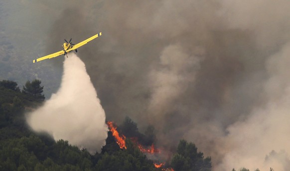 A firefighting plane drops water during fire extinguish works in Viver, eastern Spain, on Wednesday, Aug. 17, 2022. The European Forest Fire Information System says 275,000 hectares (679,000 acres) ha ...