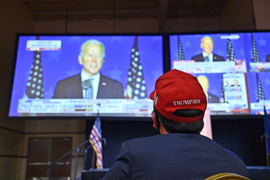 epa08797612 A President Donald Trump supporter listens to Democratic Presidential candidate Joe Biden during a Republican watch party at the South Point Hotel &amp; Casino in Las Vegas, Nevada, USA, 0 ...
