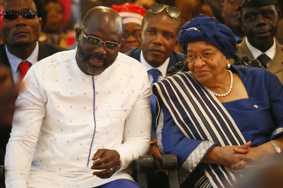 epa06462264 Liberia&#039;s president elect, George Weah (L), outgoing President Ellen Johnson Sirleaf (R) attend an intercessory prayer service at the Cemtennial Memorial Pavilion in Monrovia, as part ...