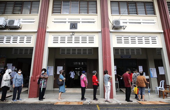 Voters wait in a line to cast their ballots for the general elections at a polling station in Kuala Lumpur, Malaysia, Saturday, Nov. 19, 2022. Malaysians began casting ballots Saturday in a tightly co ...