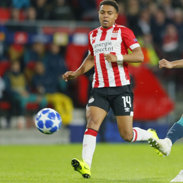 Tottenham midfielder Lucas Lucas soots on goal as PSV&#039;s Donyell Malen runs alongside during a Group B Champions League soccer match between PSV Eindhoven and Tottenham Hotspur at the Philips stad ...
