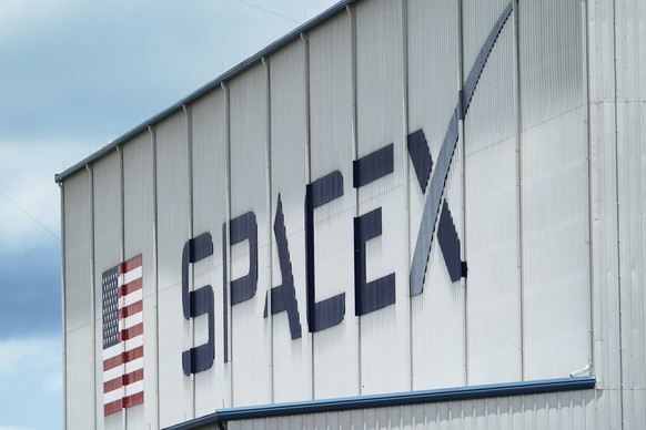 FILE - The SpaceX logo is displayed on a building, Tuesday, May 26, 2020, at the Kennedy Space Center in Cape Canaveral, Fla. Several SpaceX employees who were fired after circulating an open letter c ...
