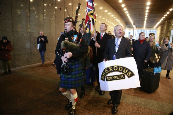 epa08181032 British Members of the European Parliament (MEPs) carrying a Union flag march out of the European Parliament with their luggage to take their train back to Britain, in Brussels, Belgium, 3 ...