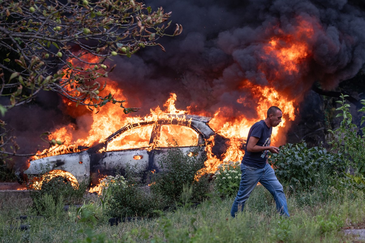 In this photo provided by Ukraine's 93rd Kholodnyi Yar Separate Mechanized Brigade press service, and taken Wednesday, Sept. 2, 2026, a resident runs away from his burning car following a Russian ...