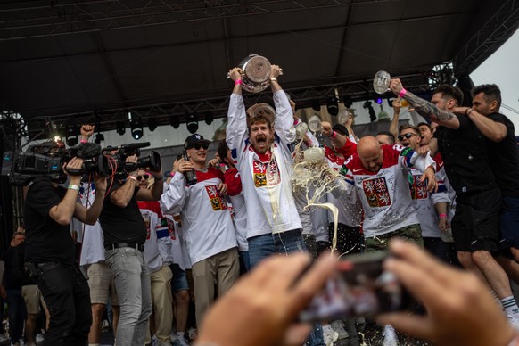 epa11373979 Czech hockey player Roman Cervenka (C) celebrates with the trophy on podium with teammates in front of fans after winning the IIHF Ice Hockey World Championship 2024, at Old Town Square, i ...