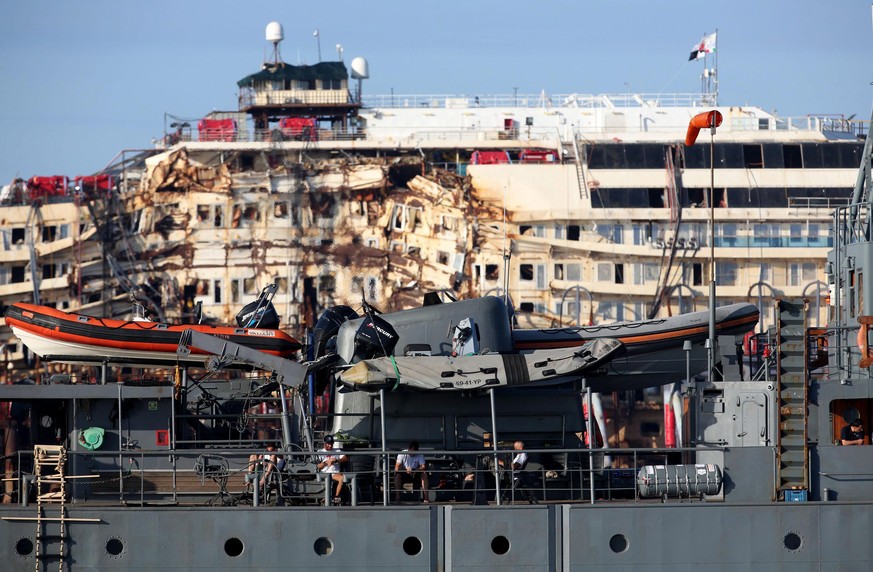 epa04328810 Workers take a rest on the deck of the Costa Concordia during his final voyage to Genoa, in the Tyrrhenian Sea, off the coast of Italy, 24 July 2014. The wreck of the Costa Concordia cruis ...