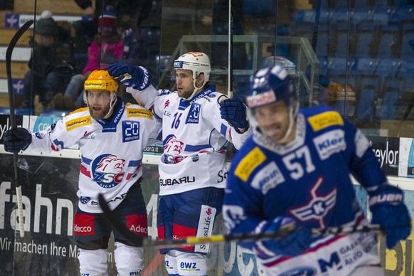 ZSC Lions Stuermer Linden Vey, Mitte, freut sich ueber seinen Treffer zum 0-1 mit Stuermer Fredrik Pettersson, links, waehrend EHC Kloten Verteidiger Lukas Stoop, rechts, davon faehrt waehrend dem Eis ...