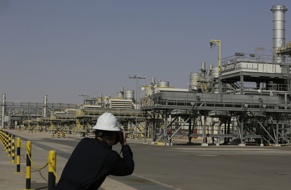 FILE - A photographer takes pictures of the Khurais oil field during a tour for journalists, 150 km east-northeast of Riyadh, Saudi Arabia, June 28, 2021. In a statement on Monday, March 21, 2022, car ...