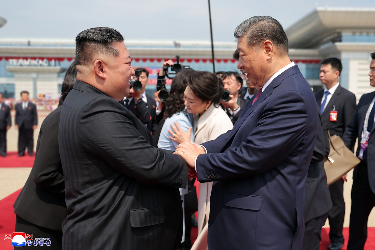 In this photo provided by the North Korean government, North Korean leader Kim Jong Un, left, and Chinese President Xi Jinping, right, shake hands before Xi's departure for China, at the airport  ...