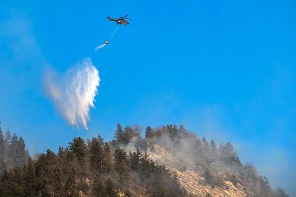 A Swiss army Superpuma Helicopter discharges water over the forest fires near Mesocco in Southern Switzerland, Wednesday, December 28, 2016. (KEYSTONE/Ti-Press/Gabriele Putzu)