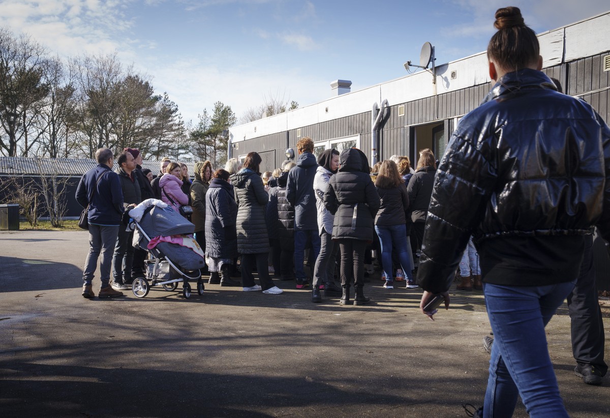 epa09827046 Ukranian refugees stand in line to be handed out pocket money in Center Dokkedal in northern Jutland, Denmark, 15 March 2022. Almost 200 persons from Ukraine arrived at the Center Dokkedal ...