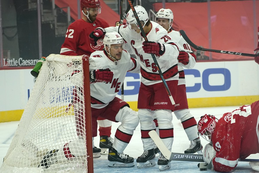 Carolina Hurricanes right wing Nino Niederreiter (21) celebrates his goal with Sebastian Aho (20) as Detroit Red Wings goaltender Thomas Greiss (29) looks at the puck in the first period of an NHL hoc ...